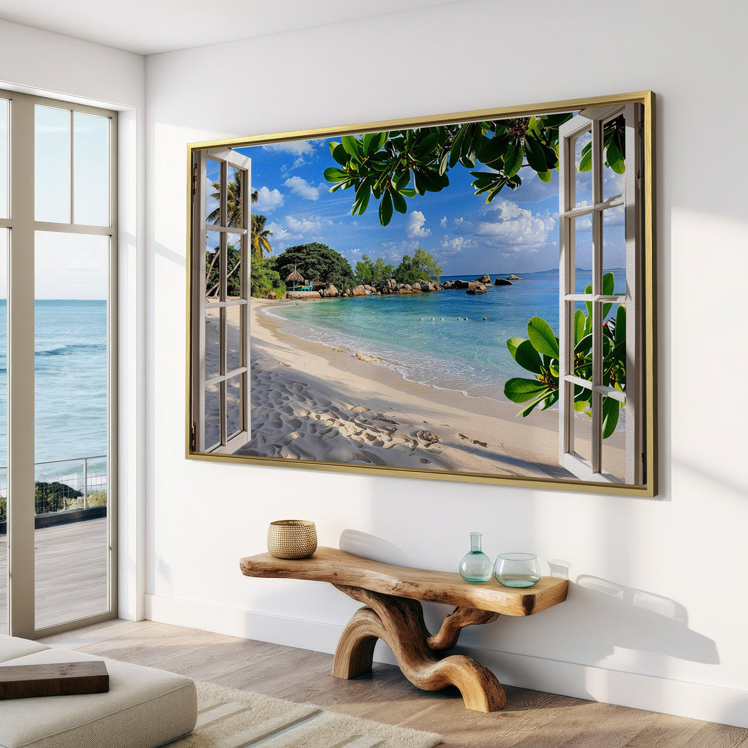 Framed Wall Art: Tropical beach scene canvas print in a bright, airy interior. Features turquoise water, white sand, and a blue sky. Perfect coastal decor!