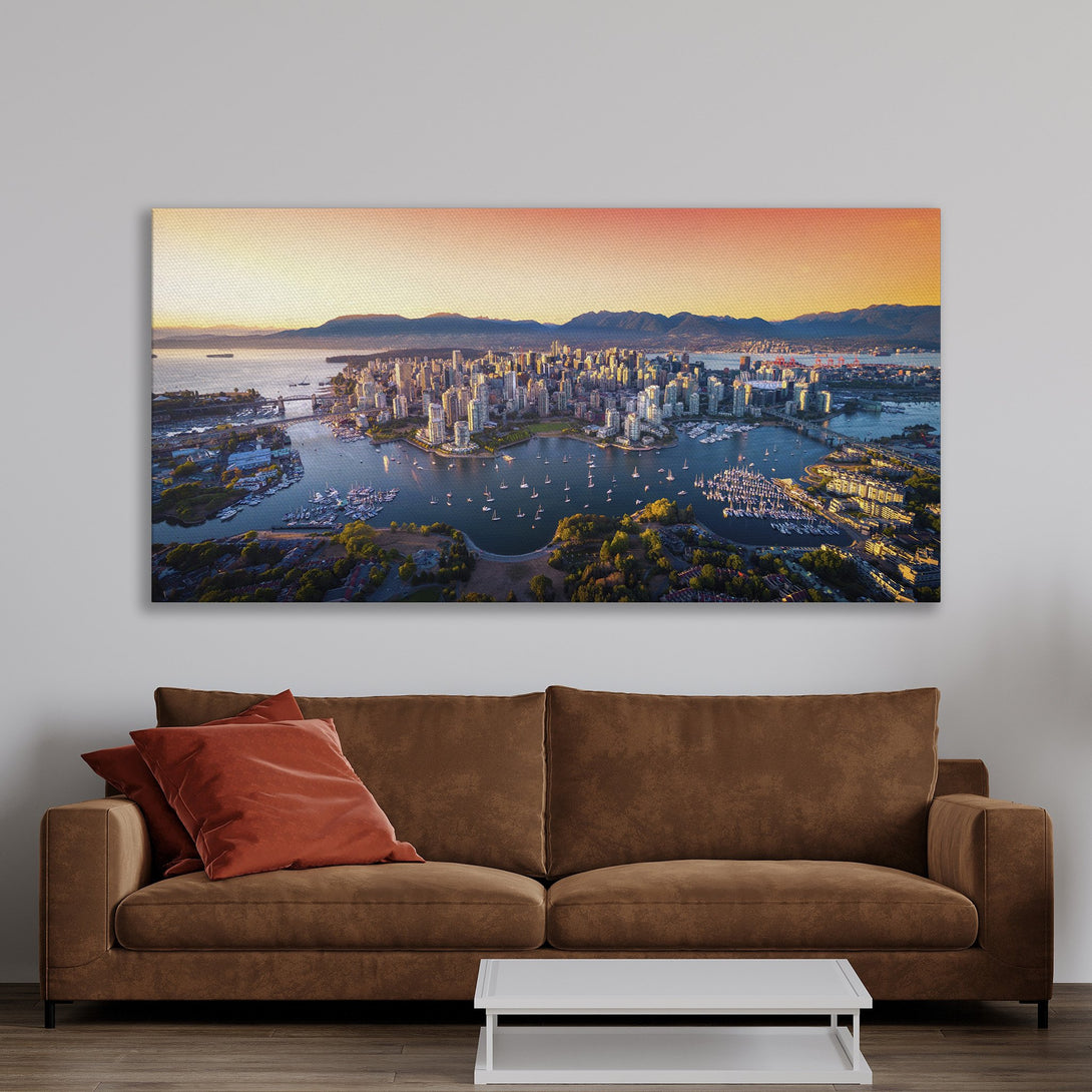 Framed Wall Art: Stunning aerial view of Vancouver city skyline with warm sunset hues. Modern decor with a gold frame, perfect for any living space.