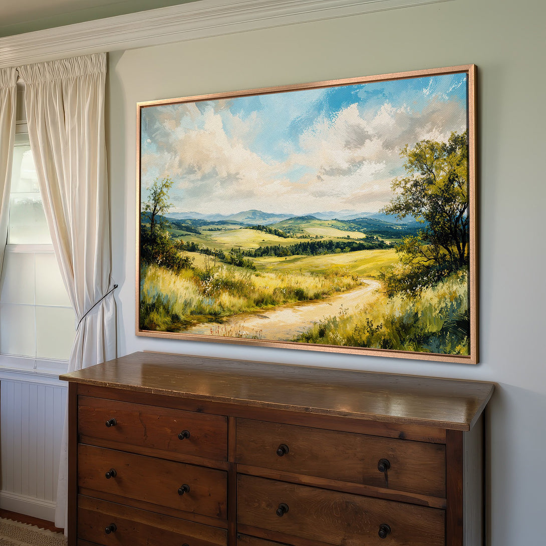 Framed Wall Art: Landscape Canvas Print in a warm, inviting interior. Features a scenic countryside view with blue sky, green fields, and yellow tones.
