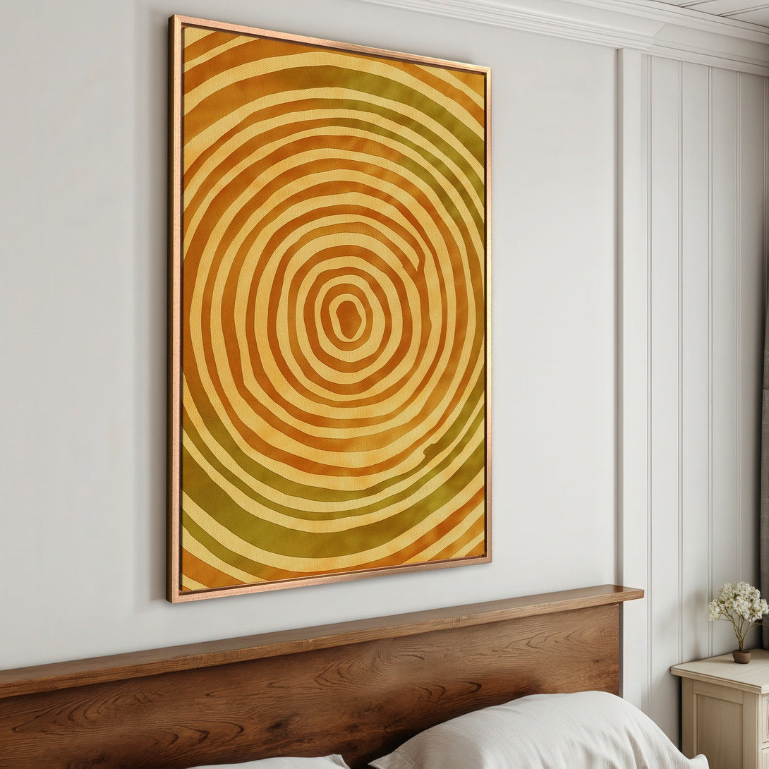 Framed Wall Art featuring an abstract, concentric circle design in warm yellow and olive tones. Perfect for adding a touch of modern art to your home.