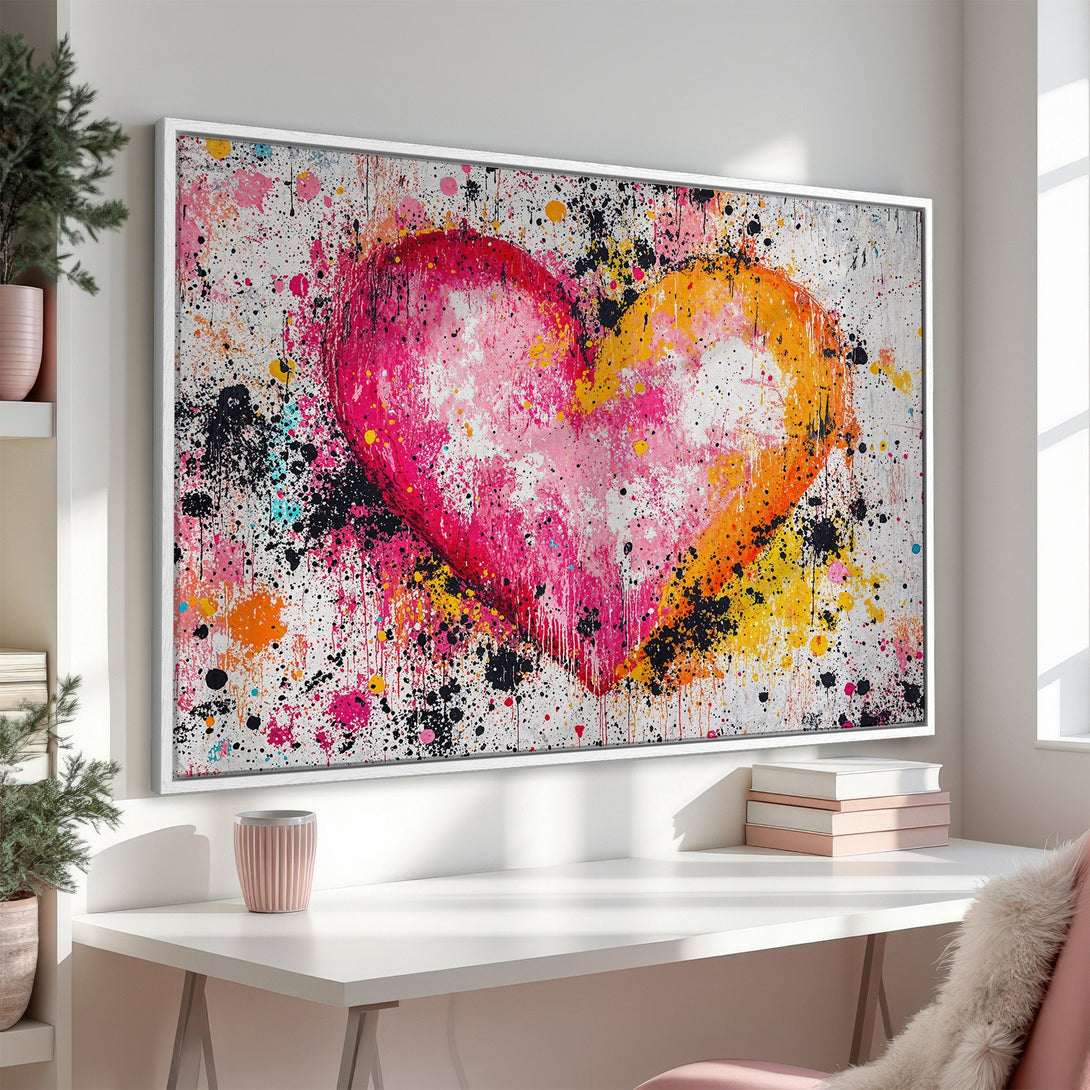 Framed Wall Art: Abstract heart canvas print in vibrant pink, orange, and yellow paint splatter. Modern art for home decor.