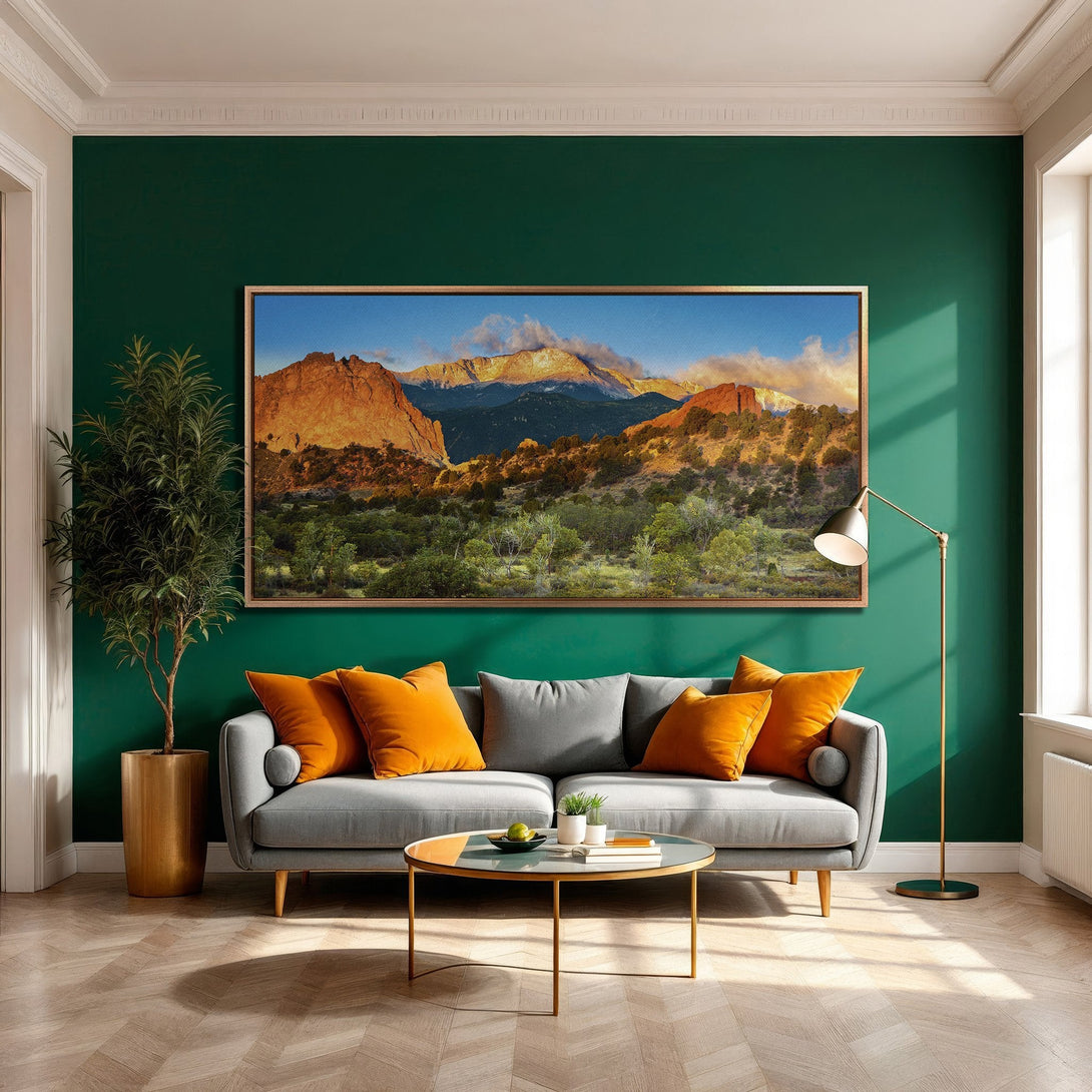 Framed Wall Art featuring a mountain landscape in warm tones. Modern decor with a green wall and pops of orange. Enhance your living room with this art!