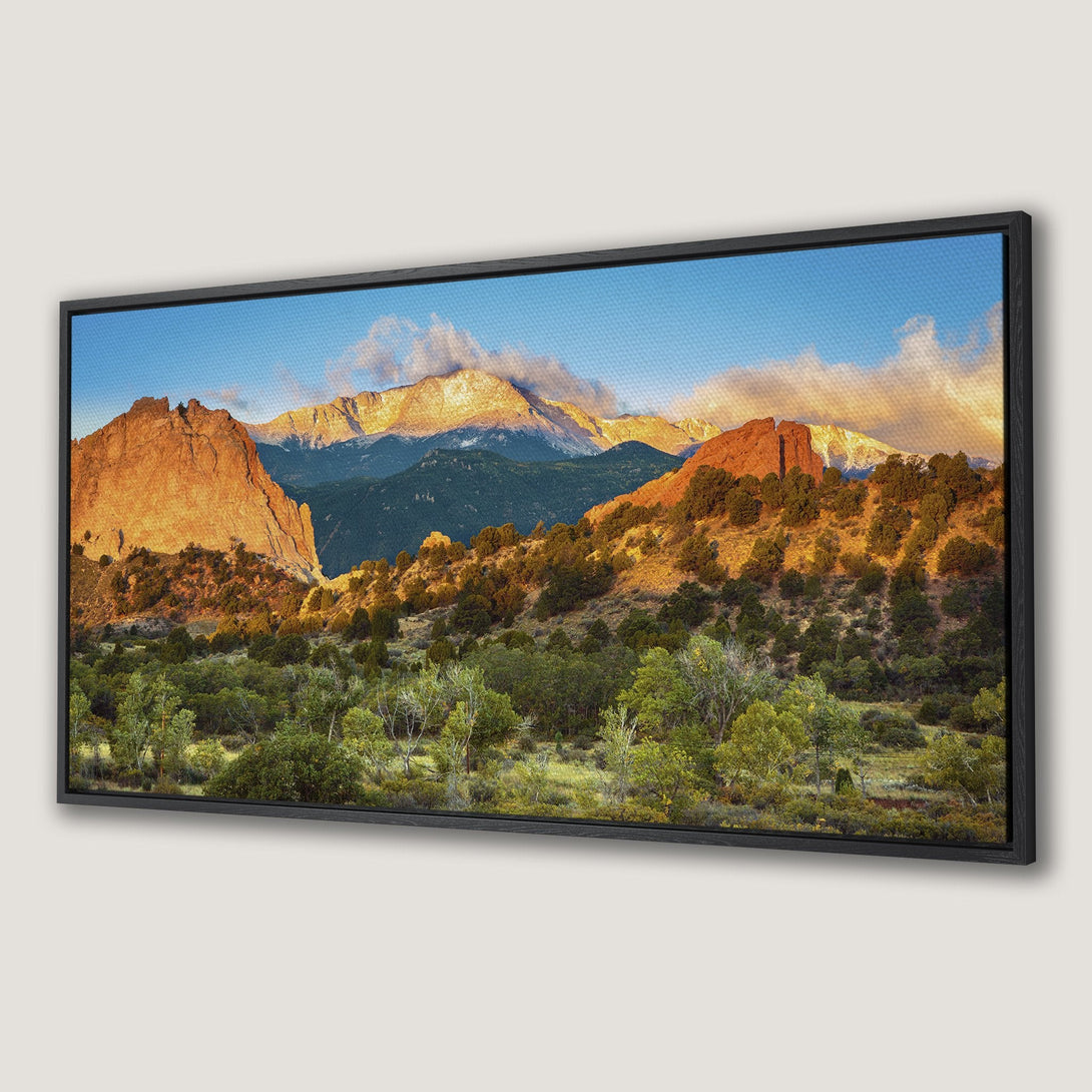 Framed Wall Art: Stunning mountain landscape Canvas Print. Warm sunset hues of orange and green create a serene, natural scene. Perfect for any home decor.