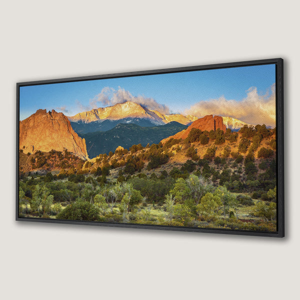 Framed Wall Art: Stunning mountain landscape Canvas Print. Warm sunset hues of orange and green create a serene, natural scene. Perfect for any home decor.