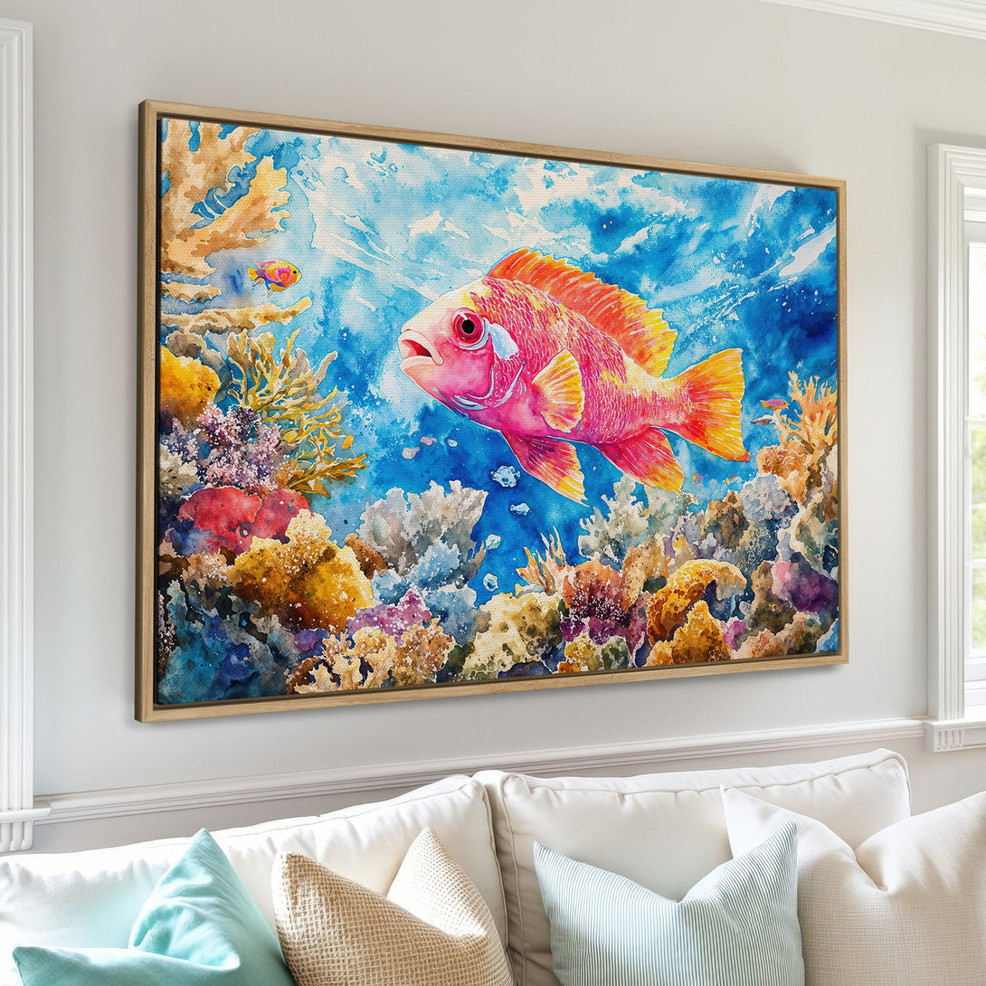 Framed Wall Art: Watercolor painting of a vibrant pink fish in a coral reef, with a blue and yellow color palette, perfect for coastal decor.