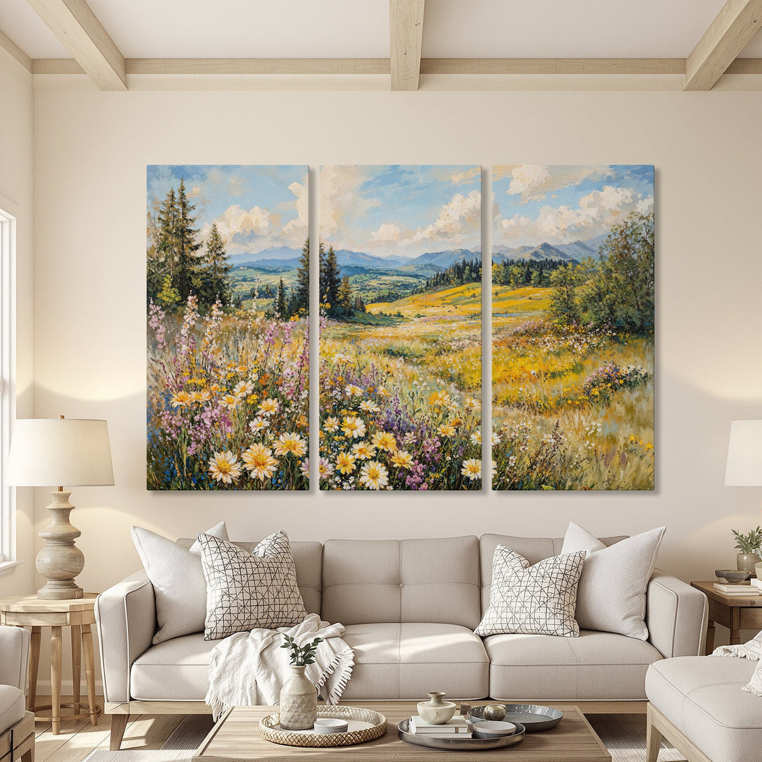 Canvas Print triptych of a vibrant wildflower meadow with blue sky and mountains, in a warm, inviting living room. Yellow, blue, and green hues.