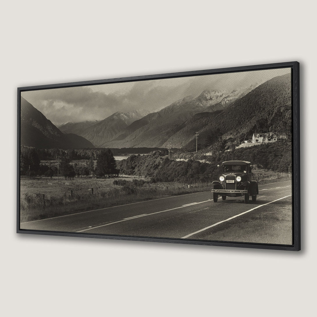 Framed Wall Art featuring a vintage car on a scenic road with mountains. Sepia-toned canvas print perfect for adding a touch of nostalgia.