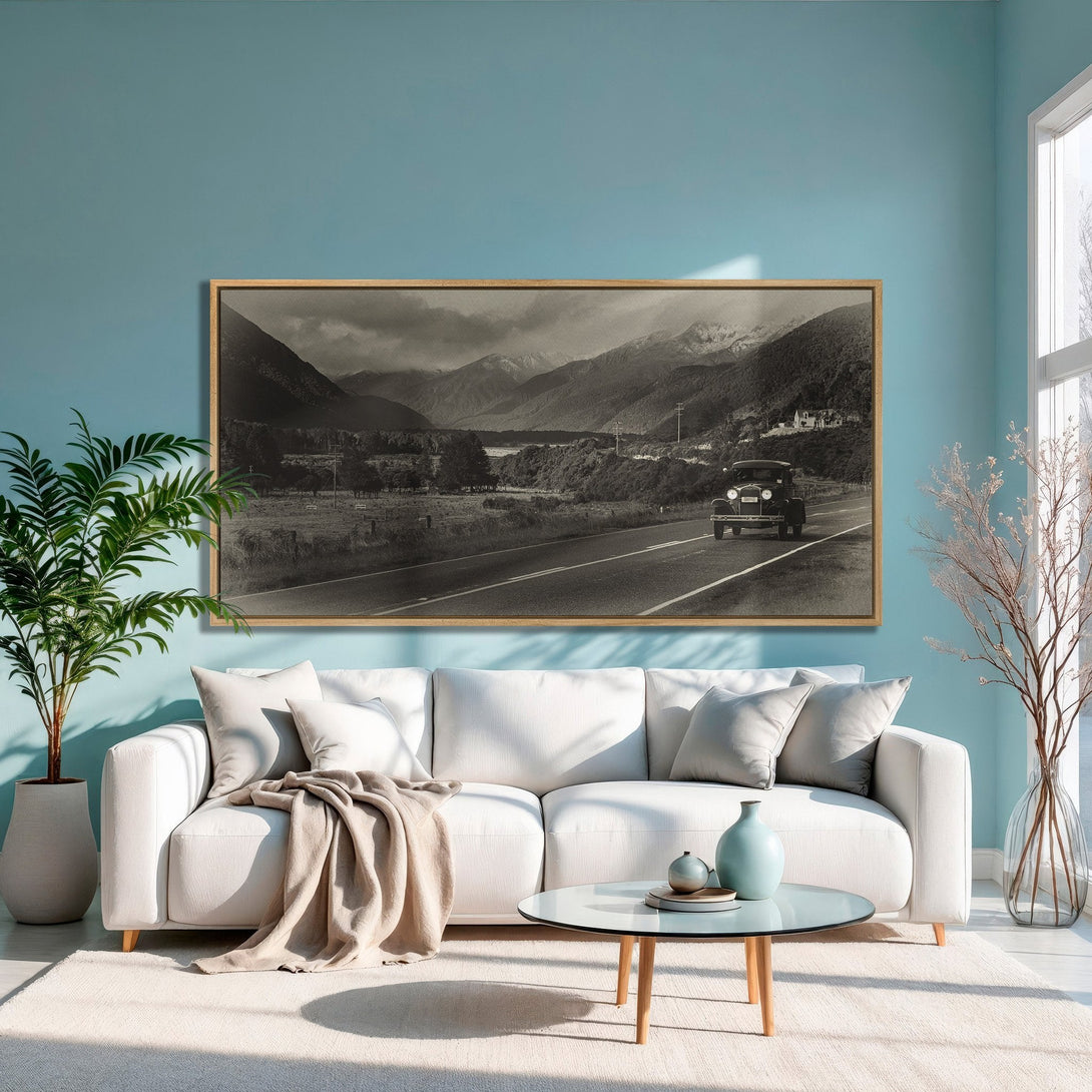 Framed Wall Art: Vintage car on a road through mountains. Black and white photograph with a neutral color palette. Perfect for modern interiors.