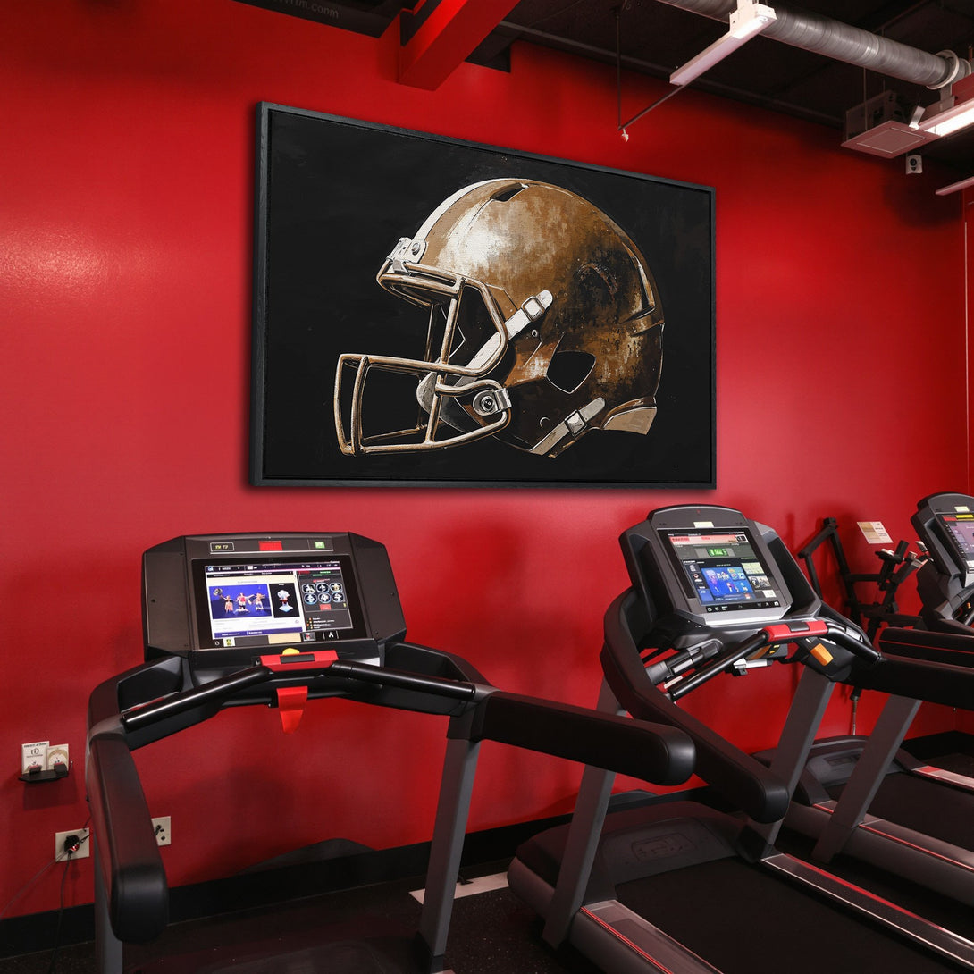 Framed Wall Art of a football helmet in a gym. Neutral tones on a black background, contrasted by a red wall. Elevate your space with this art.