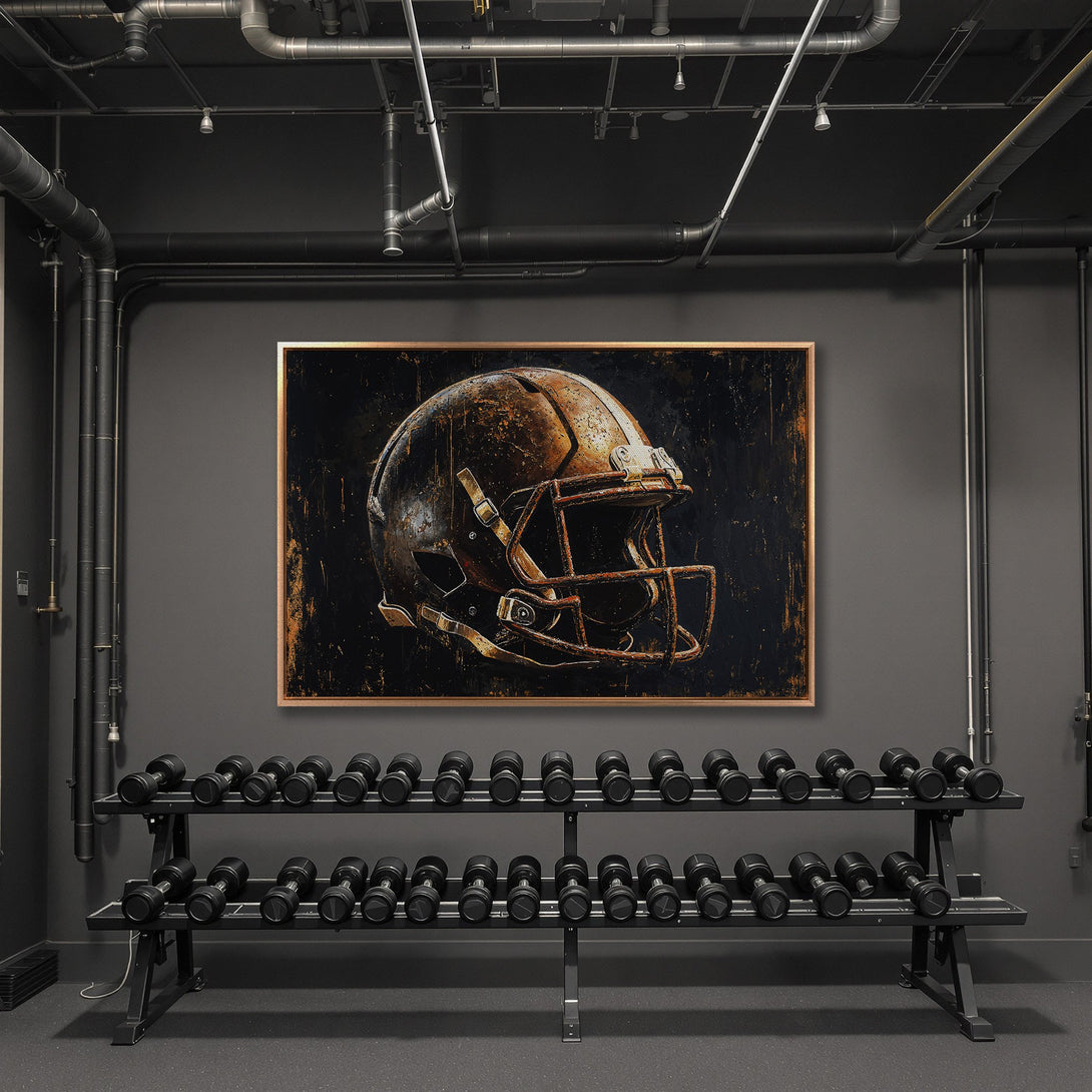 Framed Wall Art: Rustic football helmet art with a bronze frame, displayed in a modern gym. Dark, moody color palette perfect for a statement piece.
