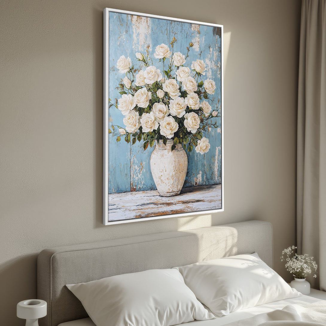 Framed Wall Art featuring a bouquet of white roses in a vase against a blue rustic background. Soft, neutral color palette for a calming interior.
