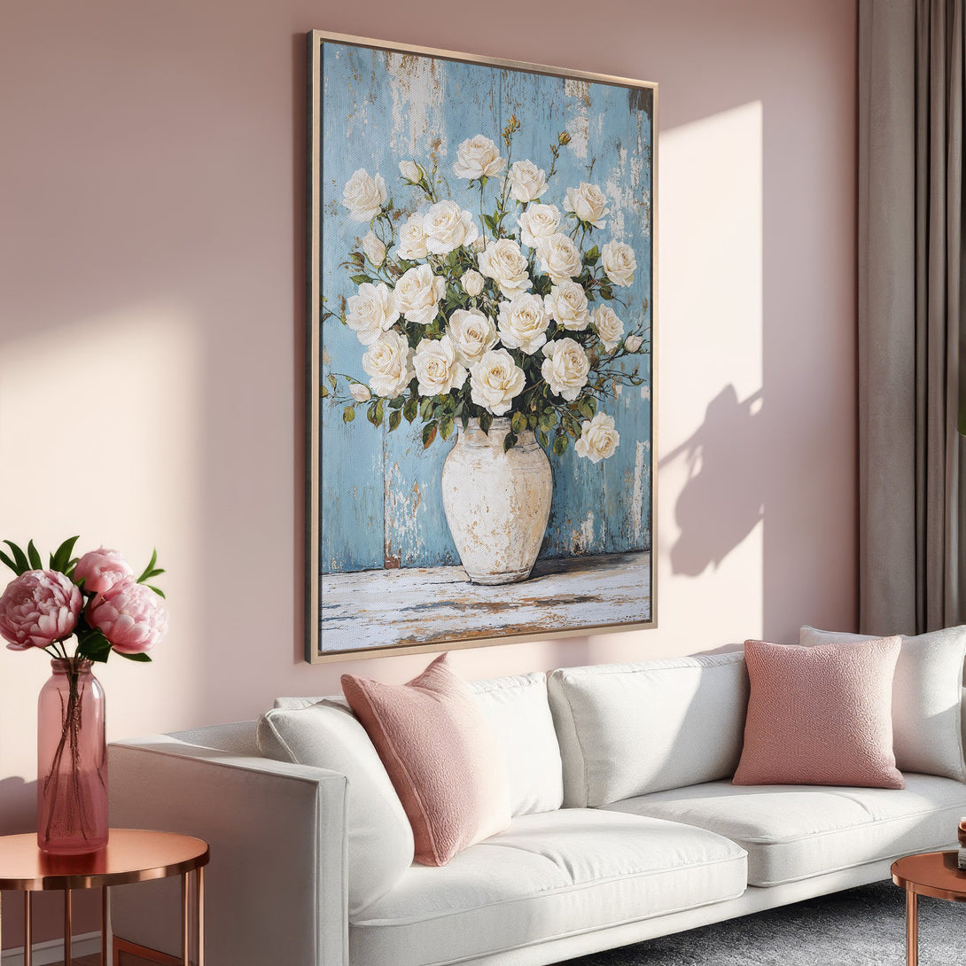 Framed Wall Art of white roses in a vase, displayed in a living room. Soft, romantic color palette with blue, white, and pink hues.