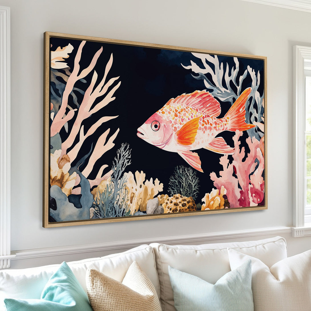 Framed Wall Art featuring a watercolor-style fish and coral reef scene in a vibrant palette of pink, orange, and blue. Perfect for coastal decor!