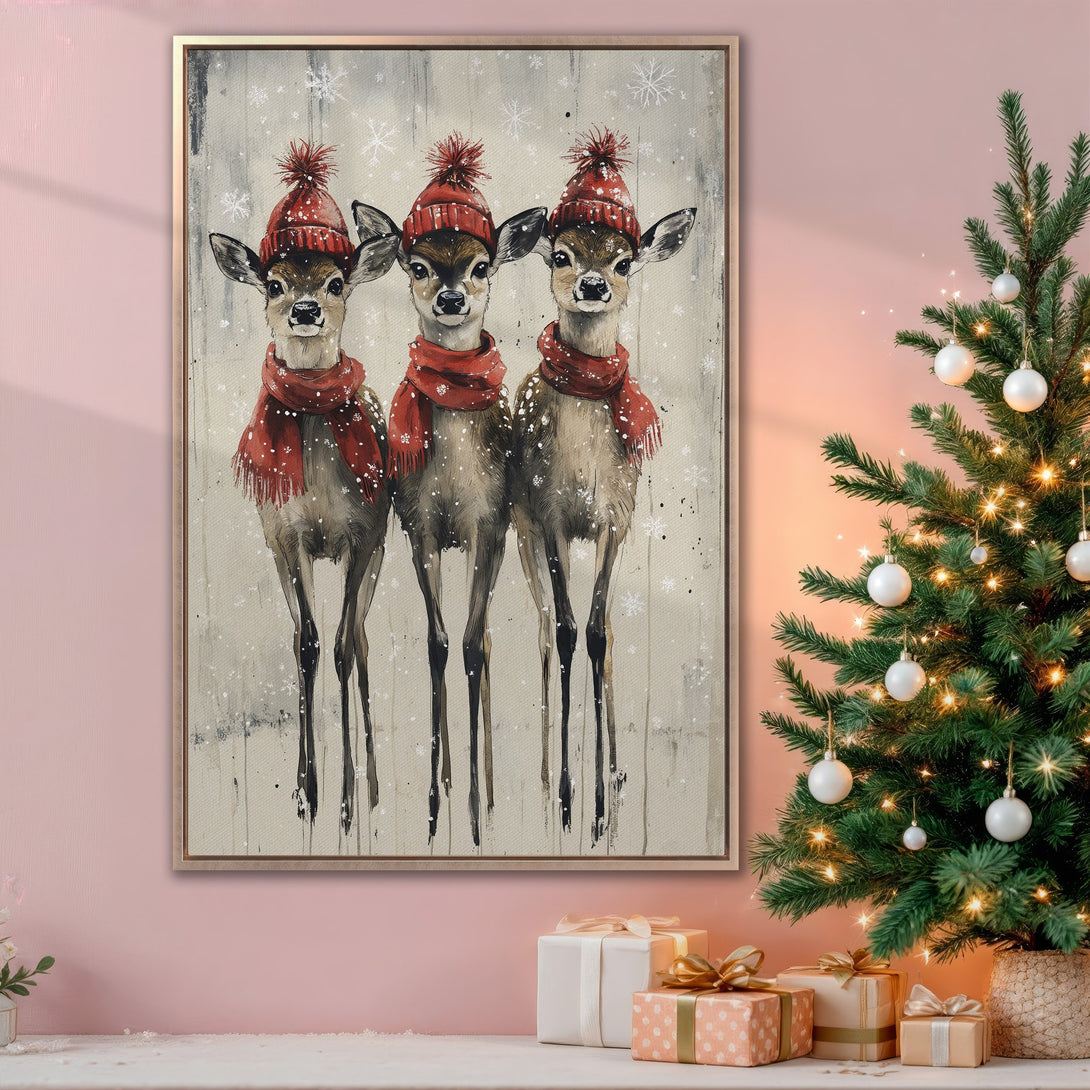 Framed Wall Art featuring three adorable deer in red hats and scarves, a cozy winter scene with a neutral and red color palette, perfect for holiday decor.