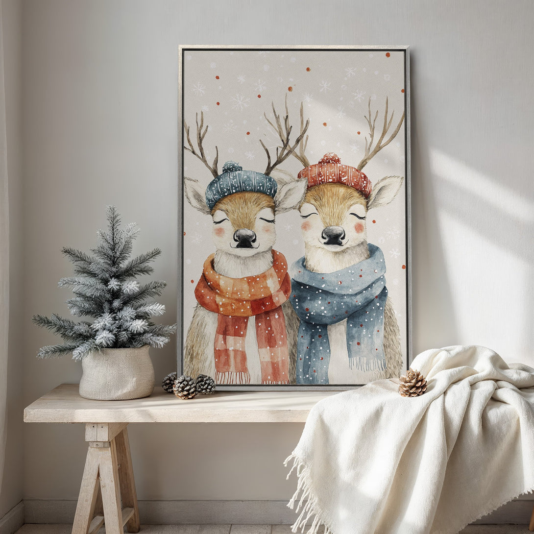Framed Wall Art featuring watercolor deer in winter hats and scarves. Warm, neutral color palette with pops of red and blue. Cozy, whimsical home decor.