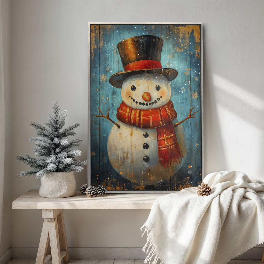 Framed Wall Art featuring a whimsical snowman in a rustic style with a blue, orange, and red color palette, perfect for winter decor.
