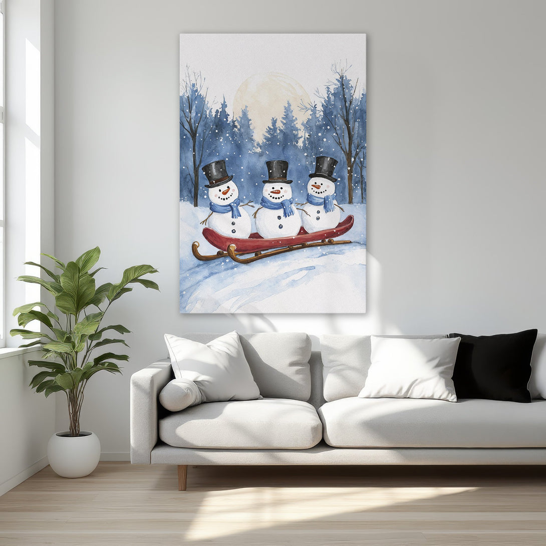 Framed Wall Art featuring watercolor snowmen on a sled in a winter scene. Blue, white, and red color palette, perfect for holiday decor.