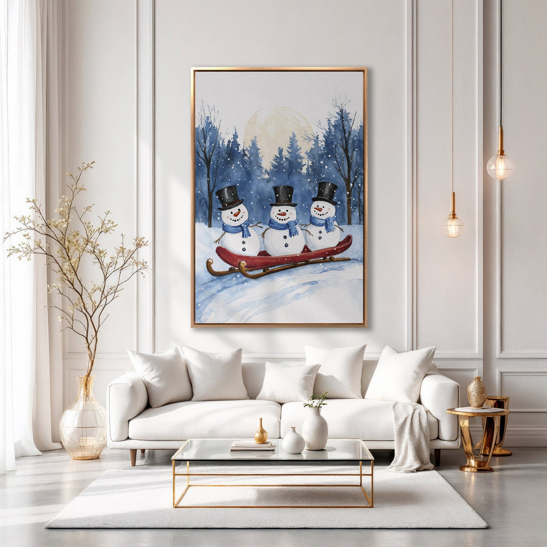 Framed Wall Art featuring watercolor snowmen on a sled, perfect for winter decor. Blue and white color palette, adds a touch of whimsy to any space.