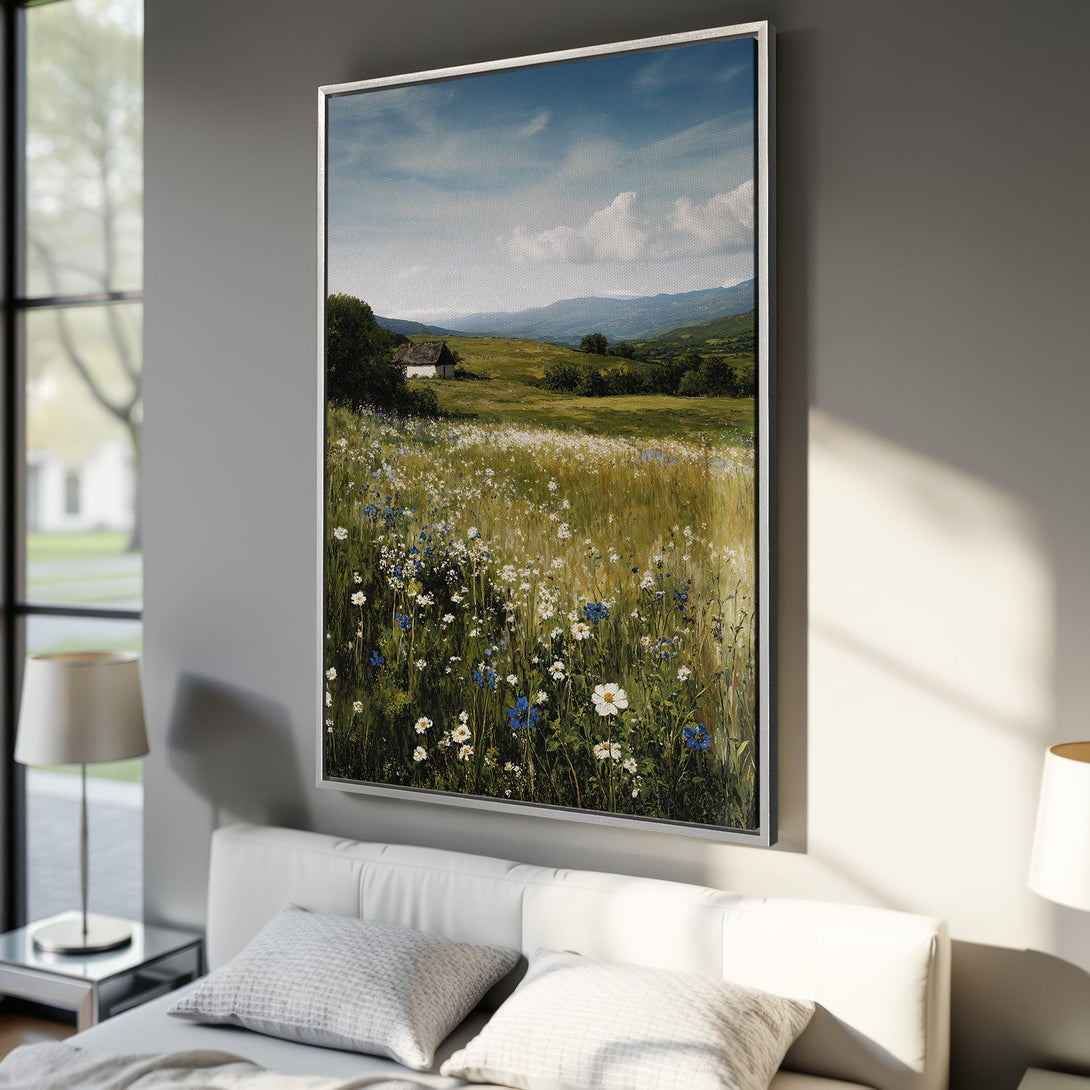 Framed Wall Art Canvas Print of a serene landscape painting with wildflowers, a cottage, and mountains. Features a natural color palette of greens, blues, and yellows.