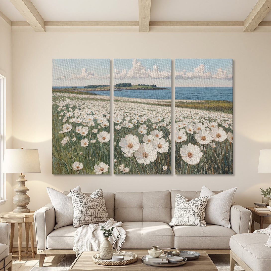 Canvas Print triptych of a coastal field of white flowers, in a serene, impressionistic style with a soft blue and green color palette. Perfect wall art!