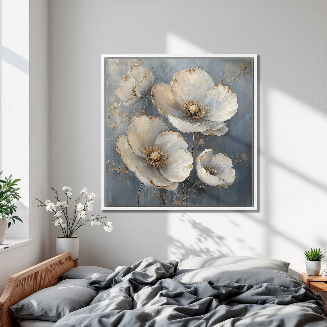Framed Wall Art: Elegant floral Canvas Print in a bedroom. Features white flowers with gold accents on a gray-blue background. Modern, stylish decor.