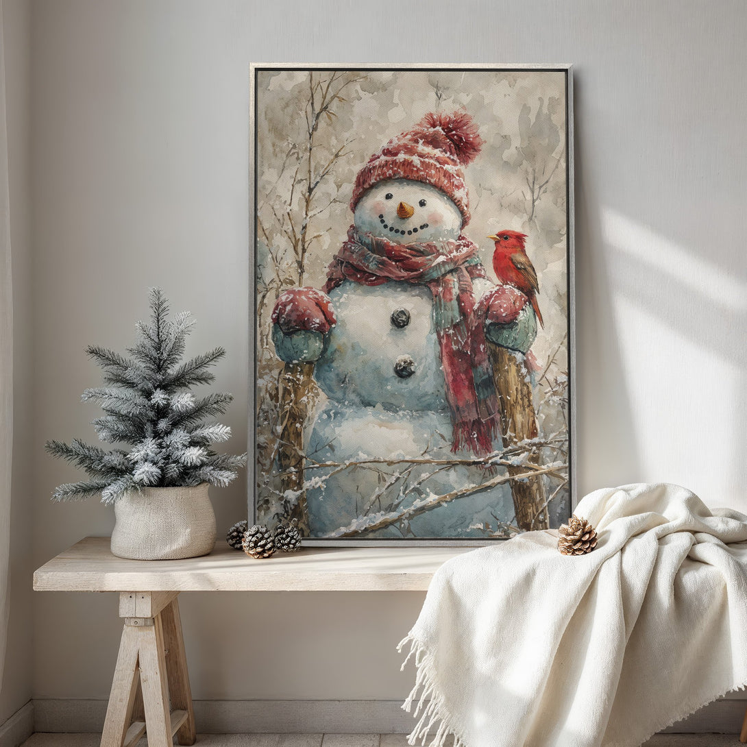 Framed Wall Art: Watercolor snowman print with red accents, perfect for winter decor. Soft, neutral color palette creates a cozy, inviting atmosphere.