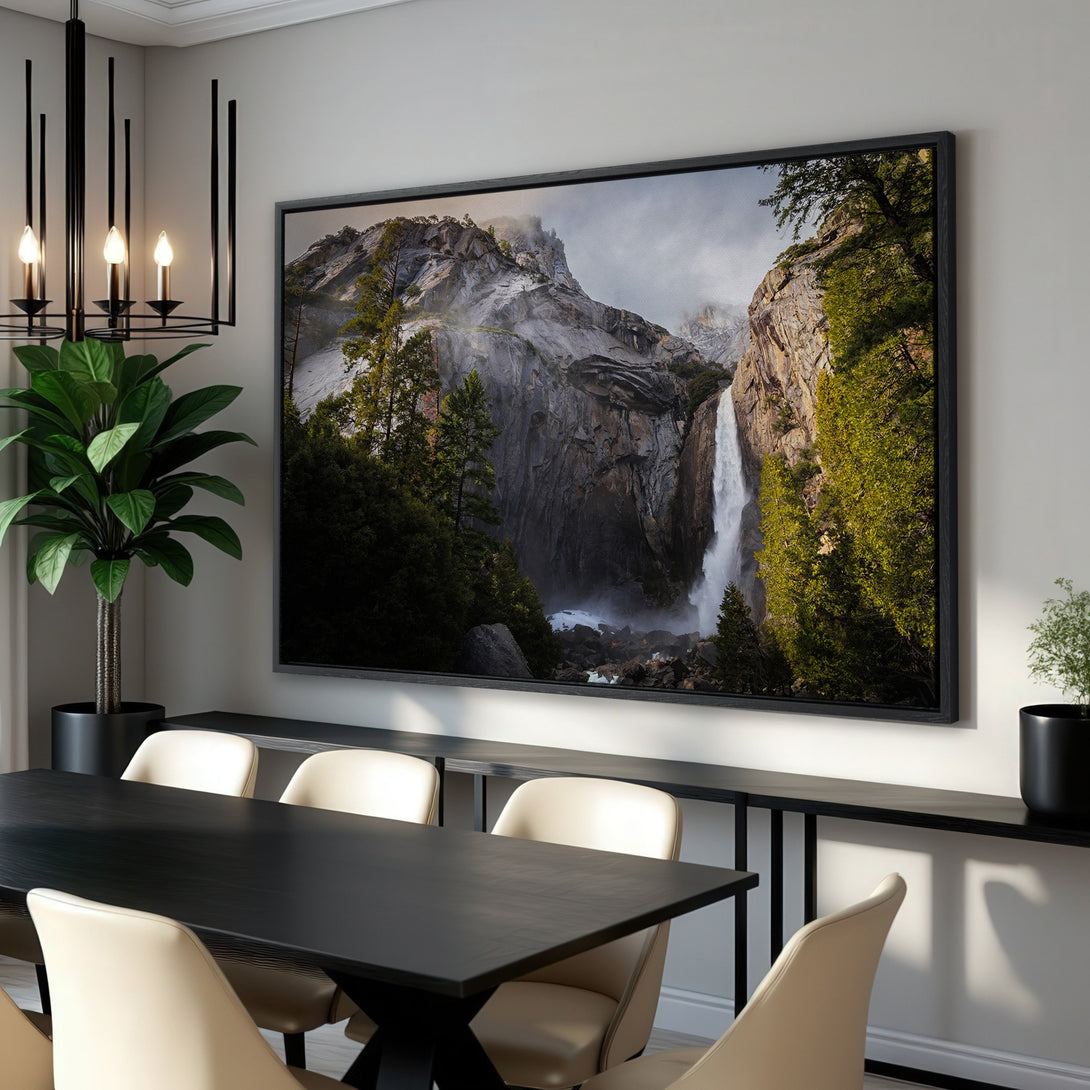 Framed Wall Art: Stunning waterfall landscape canvas print in a modern dining room. Earthy tones of green, gray, and brown create a serene atmosphere.