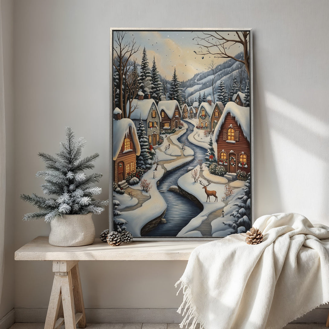 Framed Wall Art of a winter village scene with snow-covered houses and a river. Warm, inviting color palette. Perfect for cozy home decor.