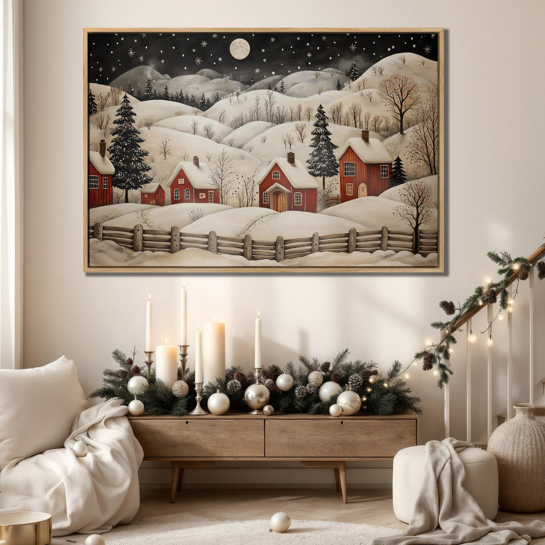 Framed Wall Art: Winter landscape Canvas Print with red houses, snowy hills, and a night sky. Cozy, rustic style with a warm, neutral color palette.