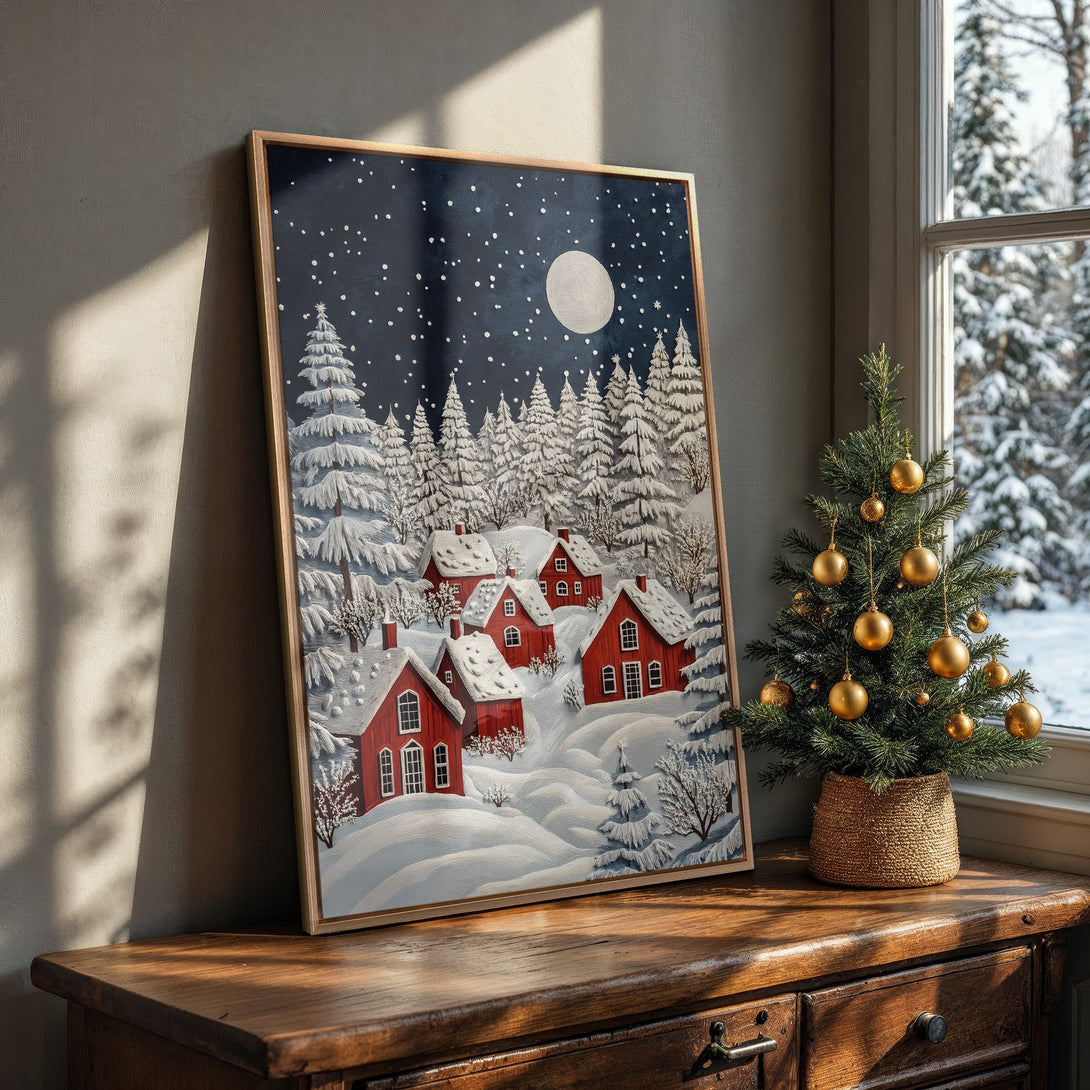 Framed Wall Art featuring a winter village scene with red houses, snowy trees, and a starry night sky. Cozy, inviting art in a blue, white, and red color palette.