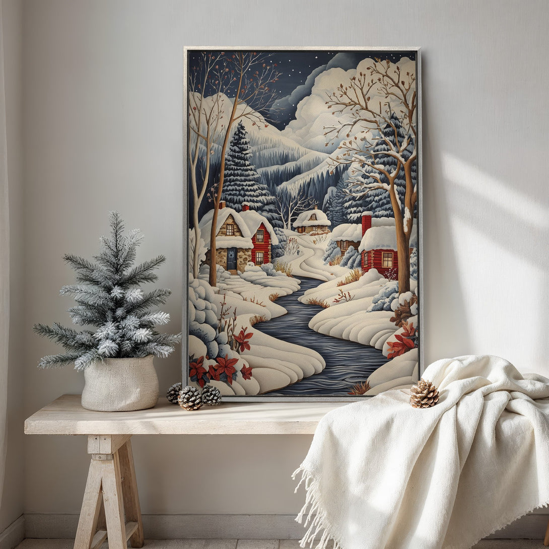 Framed Wall Art featuring a winter landscape with snow-covered houses, river, and trees. Cozy, whimsical style with a cool blue and red color palette. Perfect for holiday decor.