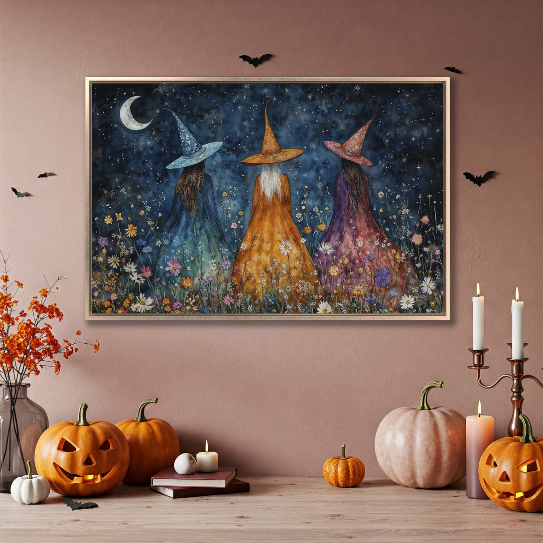 Framed Wall Art: Watercolor painting of three witches under a starry night sky. Halloween decor in blue, orange, and purple.